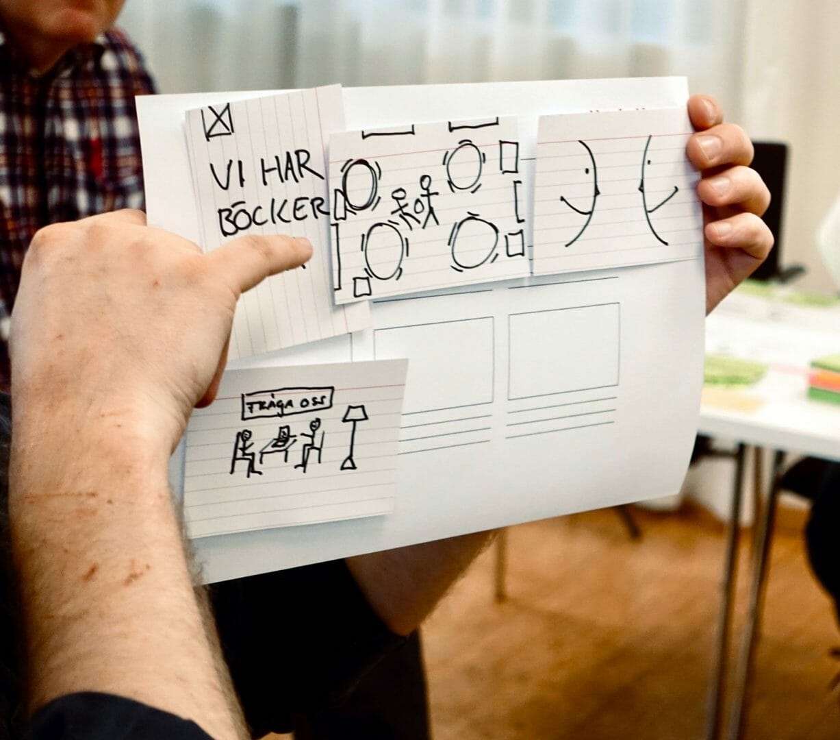 LibraryUX: hands holding a paper prototype with sketched interface cards